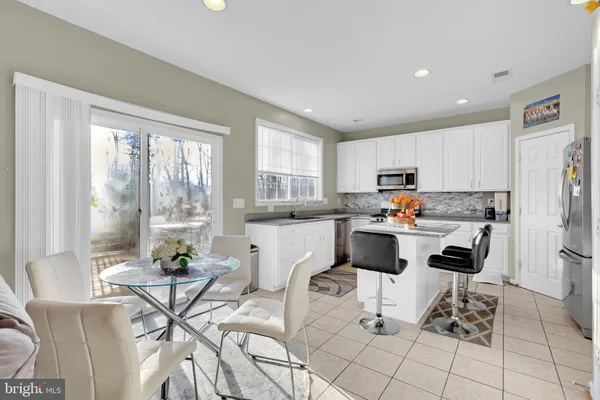 a kitchen with a refrigerator a stove a dining table and chairs