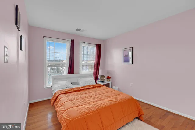a bedroom with a bed and a wooden floor