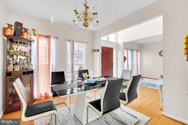 a dining room with furniture a chandelier and wooden floor