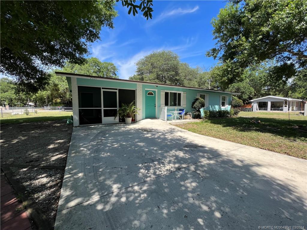 a front view of a house with a yard and trees
