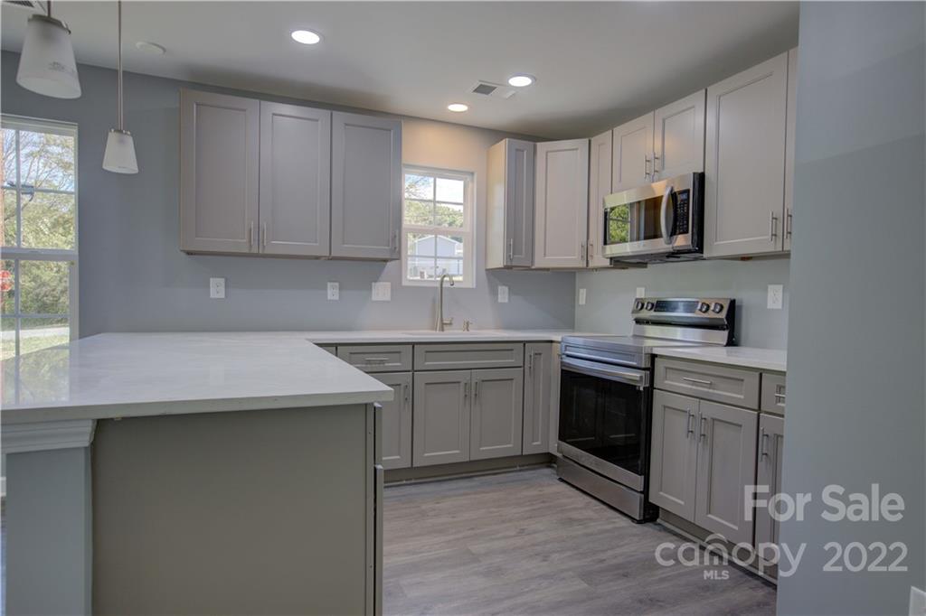 1129 5th Street Lancaster, SC 29720 - Photo 13 of 37 a kitchen with stainless steel appliances granite countertop a sink dishwasher a stove and a microwave oven with cabinets