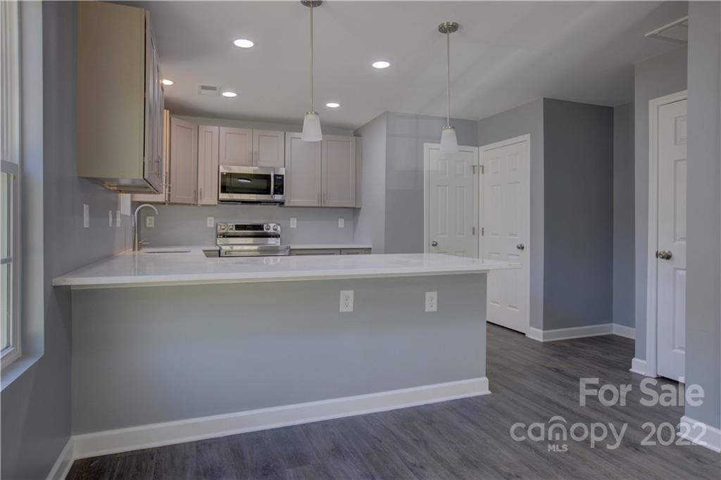 1129 5th Street Lancaster, SC 29720 - Photo 14 of 37 a view of kitchen with stainless steel appliances granite countertop refrigerator oven a sink and dishwasher with wooden floor