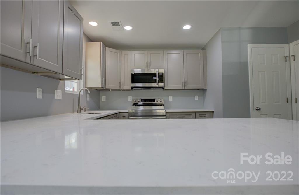 1129 5th Street Lancaster, SC 29720 - Photo 15 of 37 a kitchen with granite countertop a stove a sink and a granite counter top