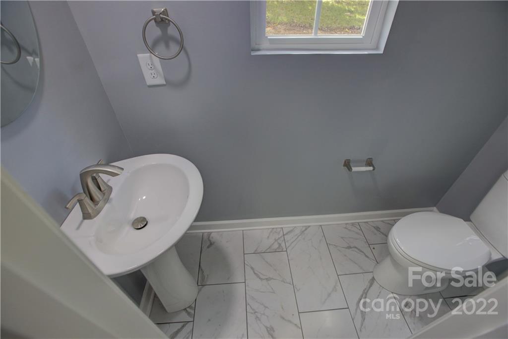 1129 5th Street Lancaster, SC 29720 - Photo 17 of 37 a bathroom with a toilet a sink and mirror