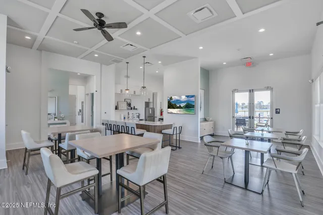 a living room with furniture a large window and wooden floor