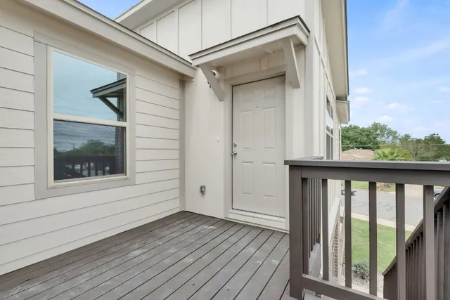 a view of a balcony with wooden floor and fence