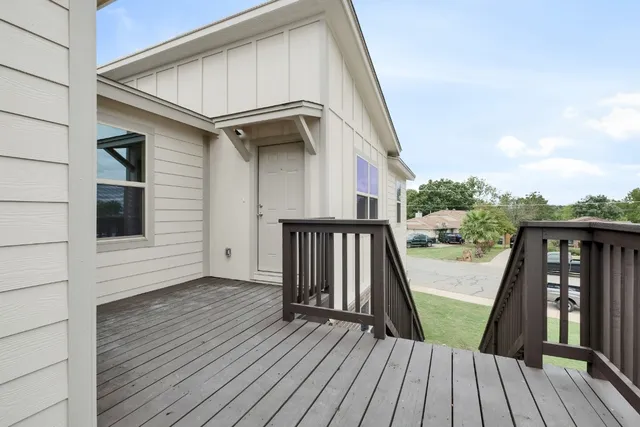 a view of a house with wooden stairs and a small yard