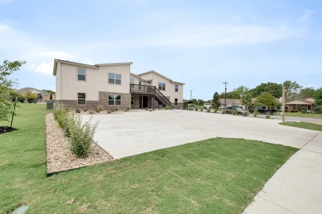 a view of a house with backyard and sitting area