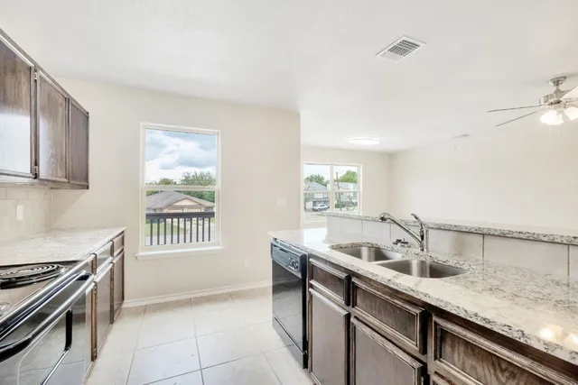 a kitchen with a sink and a stove top oven