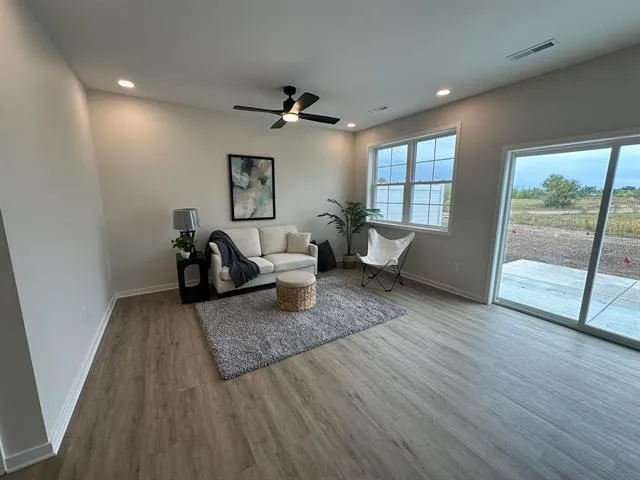 a living room with furniture and wooden floor