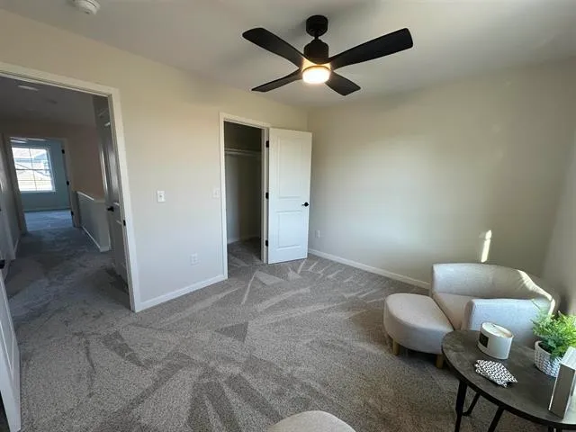 a living room with furniture and a ceiling fan