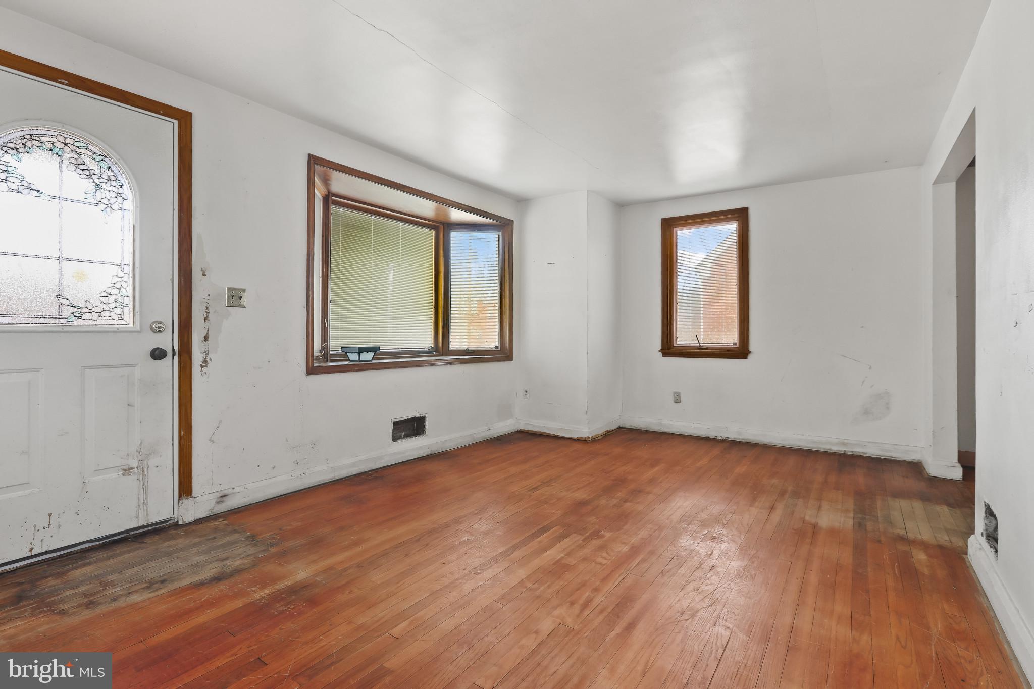 409 Oak Court Baltimore, MD 21228 - Photo 5 of 29 a view of an empty room with wooden floor and a window