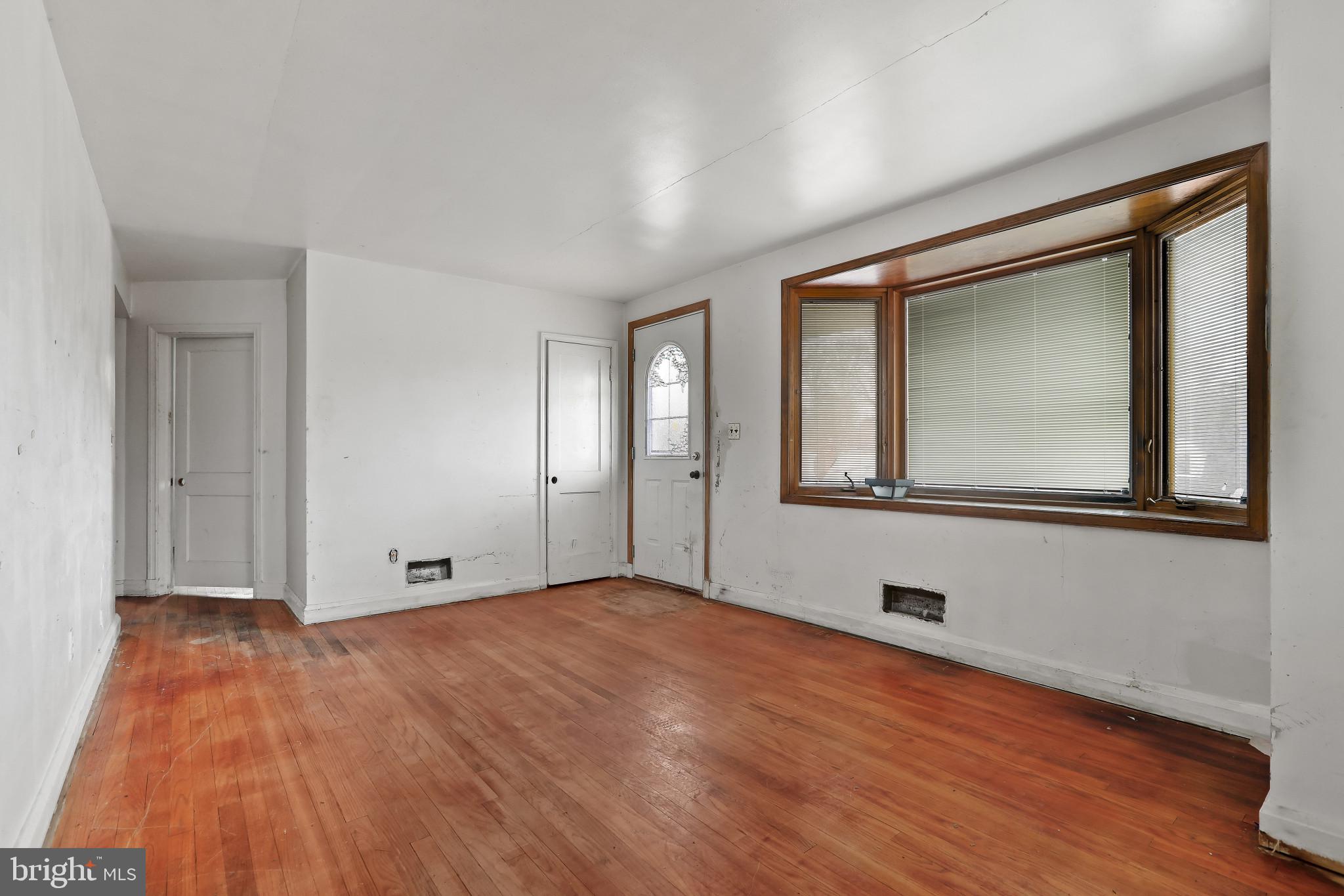 409 Oak Court Baltimore, MD 21228 - Photo 6 of 29 a view of an empty room with wooden floor and a window