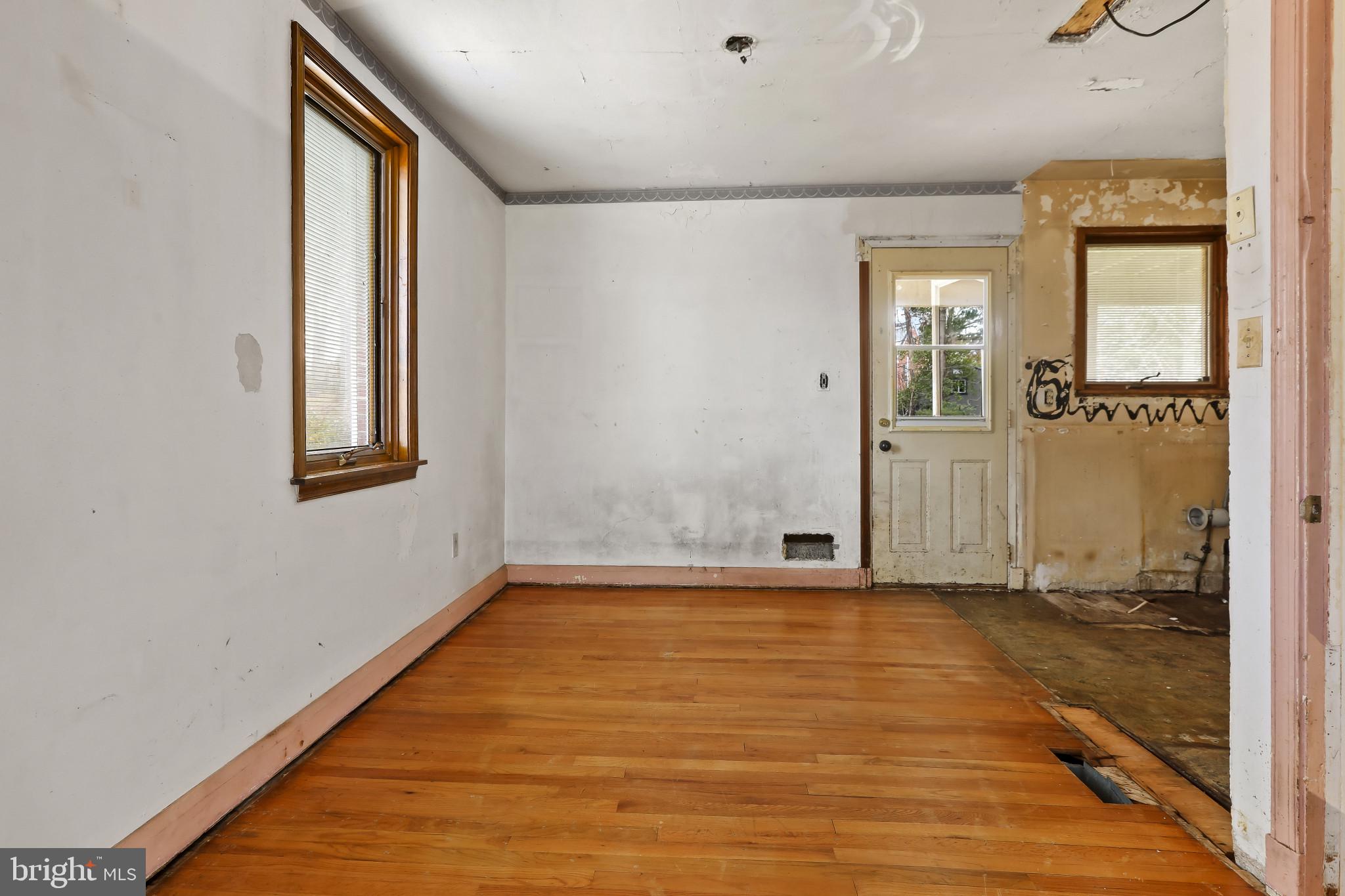 409 Oak Court Baltimore, MD 21228 - Photo 7 of 29 an empty room with wooden floor and windows