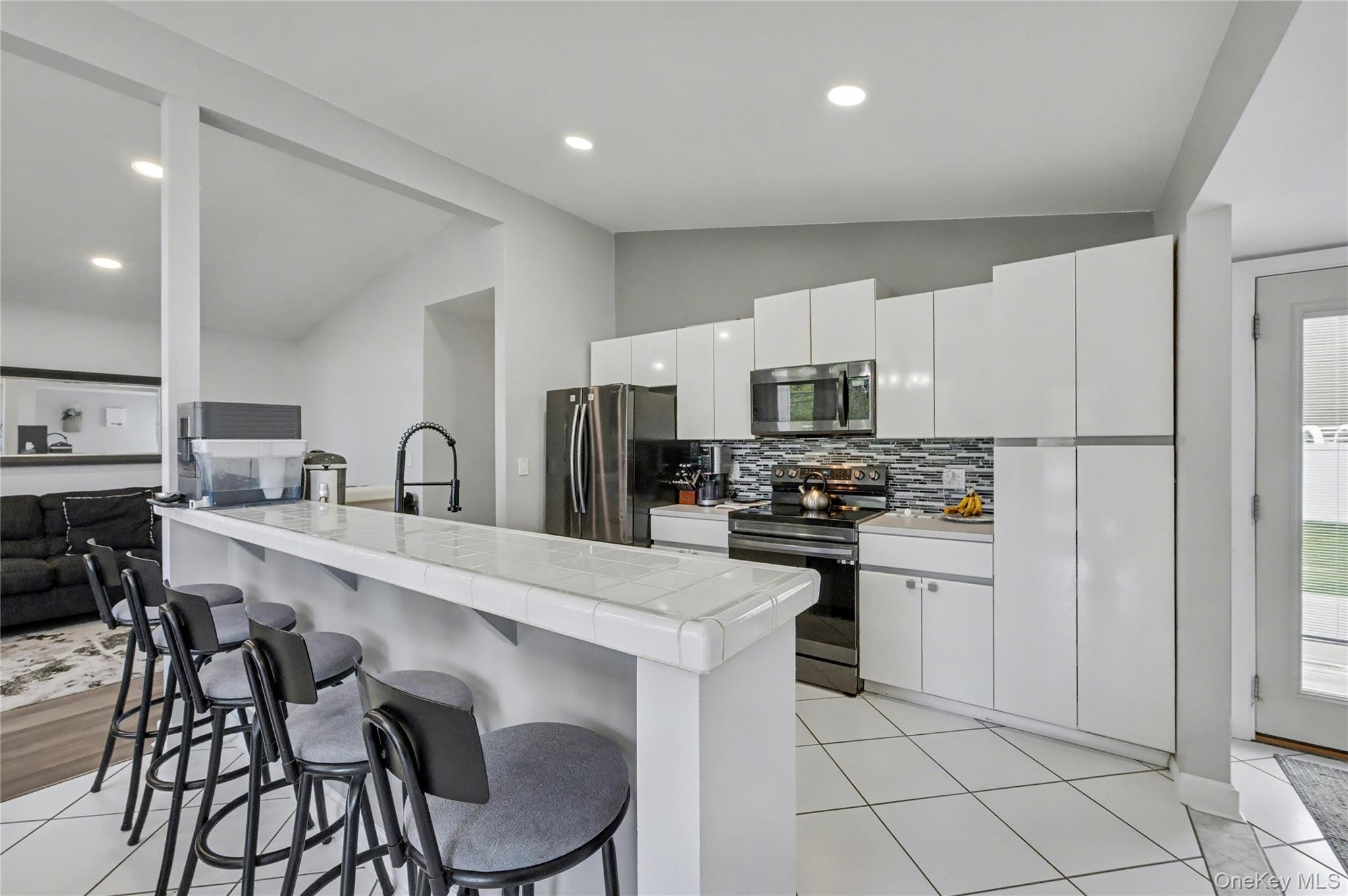 1298 Pulaski Road East Northport, NY 11731 - Photo 15 of 41 a kitchen with stainless steel appliances a stove a sink a microwave a refrigerator and cabinets
