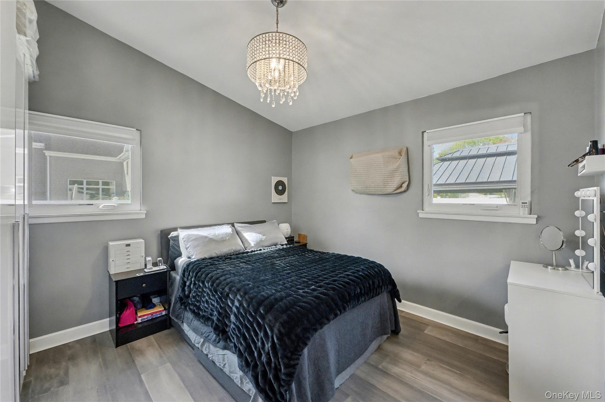 1298 Pulaski Road East Northport, NY 11731 - Photo 21 of 41 a bedroom with a bed and a chandelier