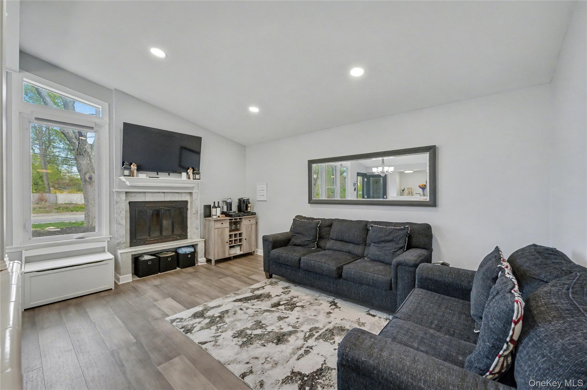 1298 Pulaski Road East Northport, NY 11731 - Photo 7 of 41 a living room with furniture a flat screen tv and a fireplace