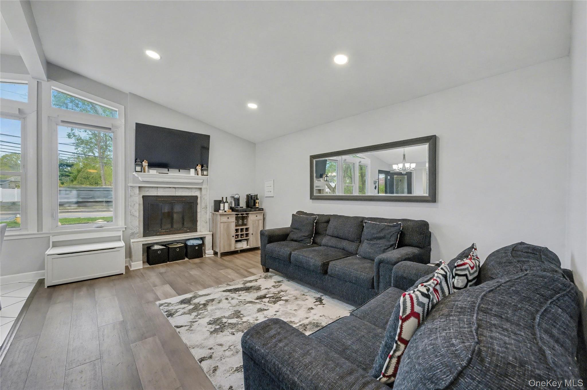 1298 Pulaski Road East Northport, NY 11731 - Photo 9 of 41 a living room with furniture a flat screen tv and a fireplace
