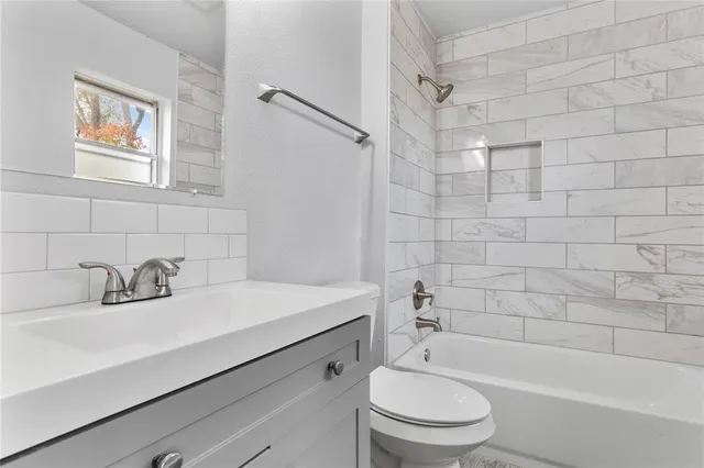 a bathroom with a sink a mirror a toilet and bathtub