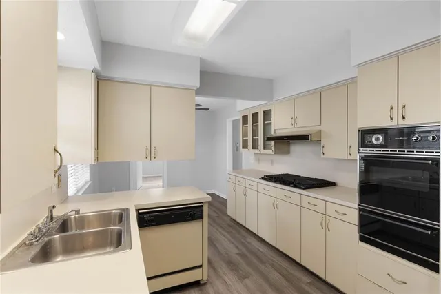 a kitchen with a sink stove top oven and cabinets