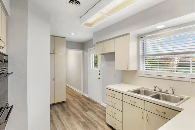 a kitchen with stainless steel appliances cabinets and a window