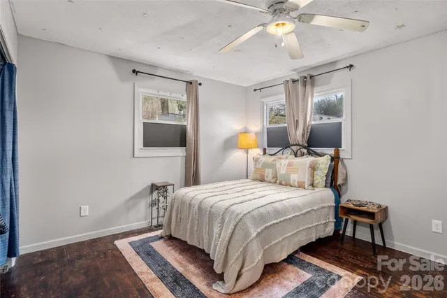 a bedroom with a bed wooden floor and window