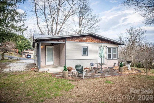 a backyard of a house with table and chairs