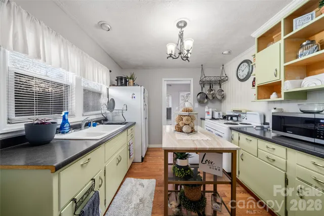 a kitchen with stainless steel appliances a table and chairs in it