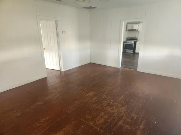 a view of a kitchen with wooden floor and a hallway