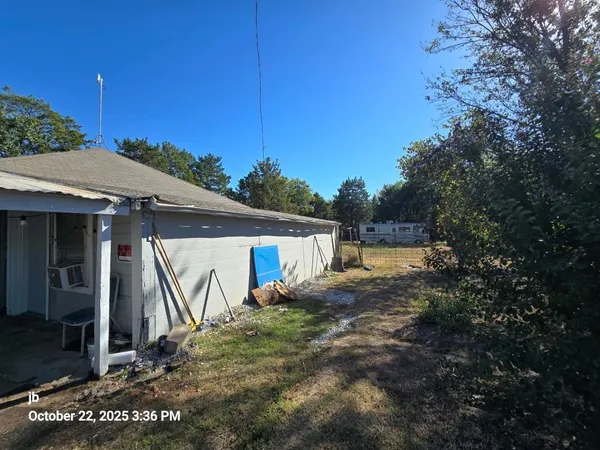 a view of a house with backyard and trees