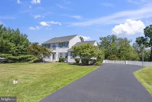 a view of a big house with a big yard and large trees