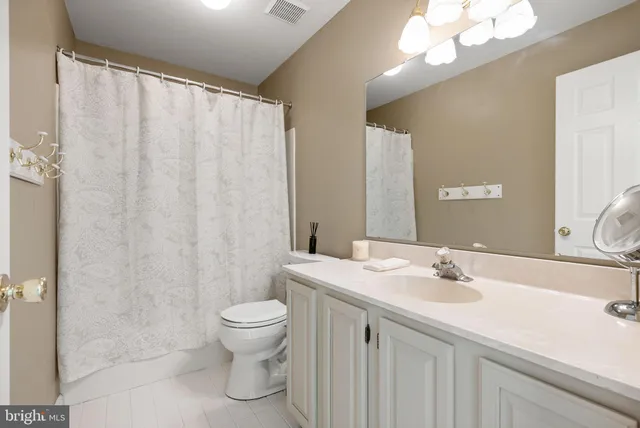 a spacious bedroom with a bed and a chandelier