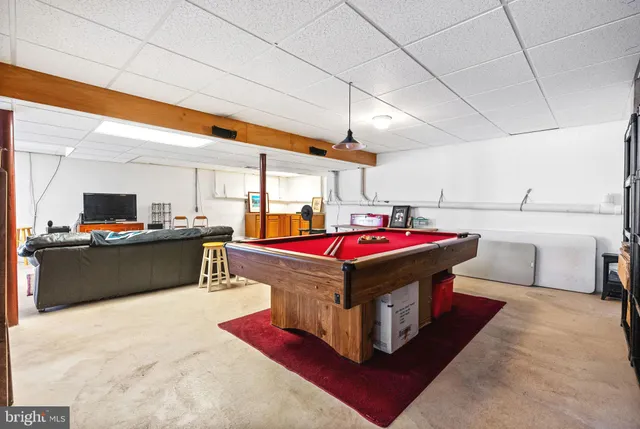 a view of a patio with a table and chairs under an umbrella with a fire pit
