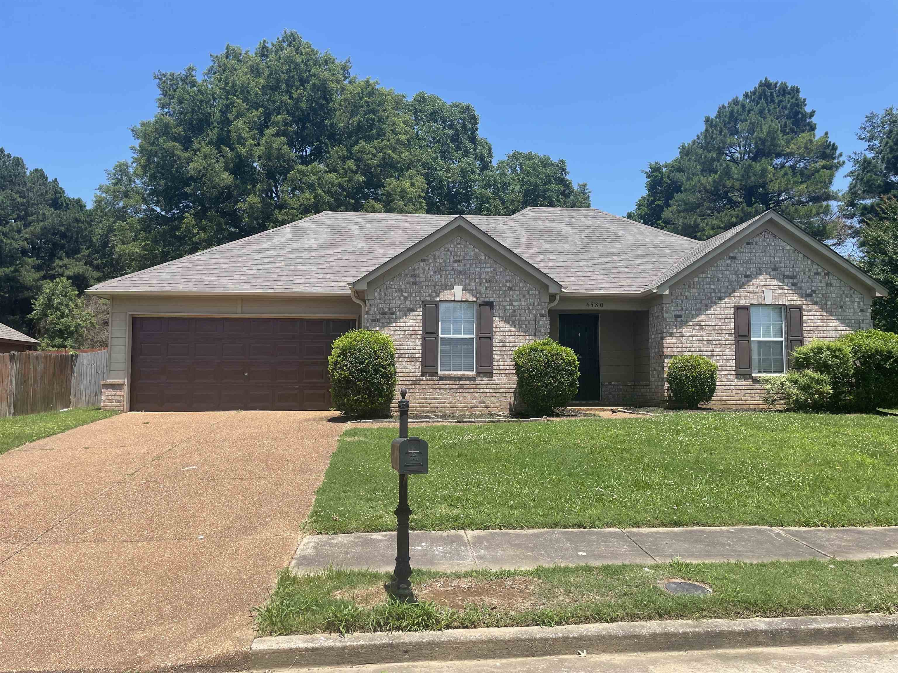 4580 Sun Ridge Drive Memphis, TN 38128 - Photo 1 of 16 Ranch-style house with a garage, brick siding, driveway, and roof with shingles