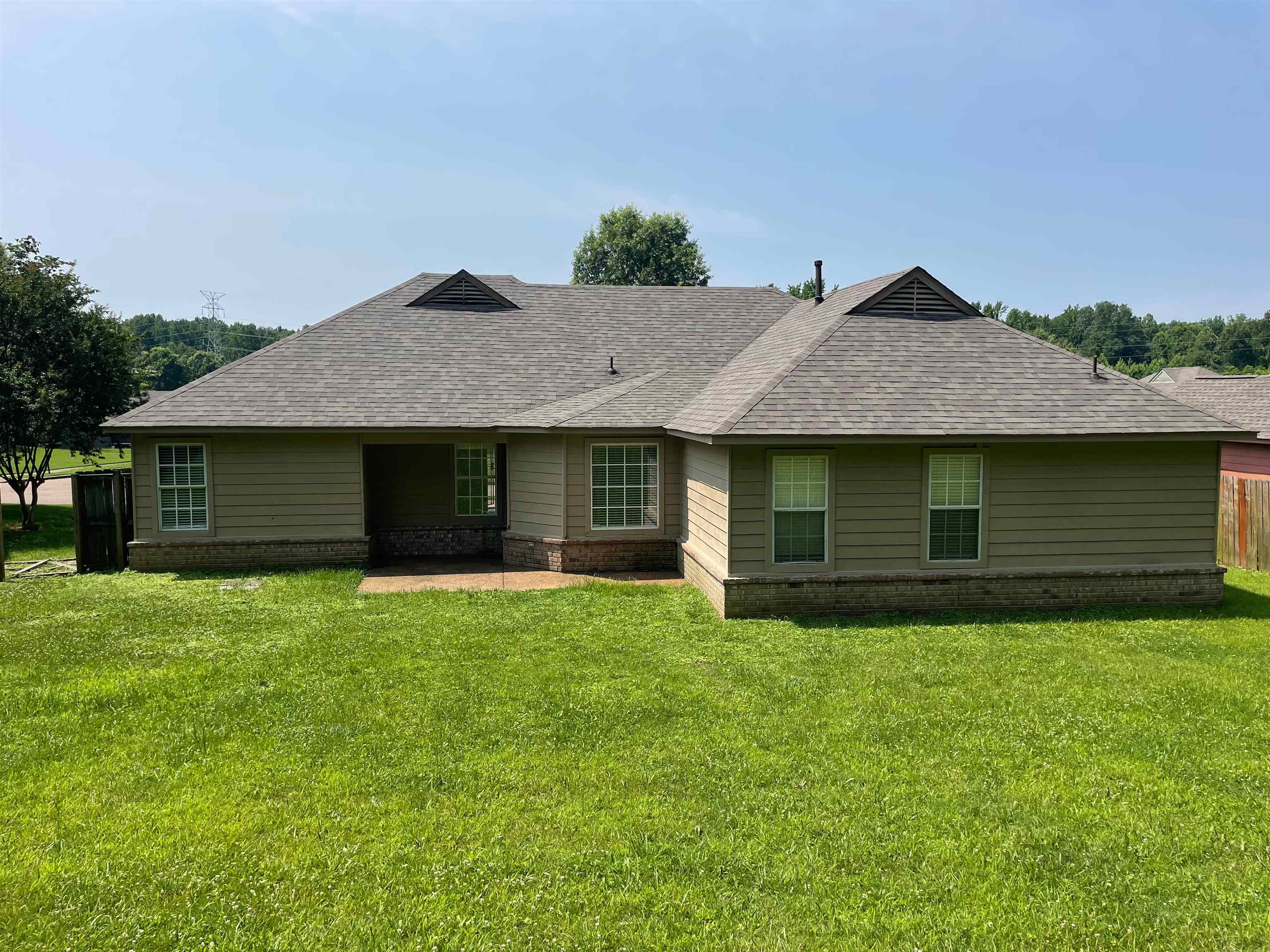 4580 Sun Ridge Drive Memphis, TN 38128 - Photo 14 of 16 View of front of property with a shingled roof, a patio area, a front lawn, and brick siding