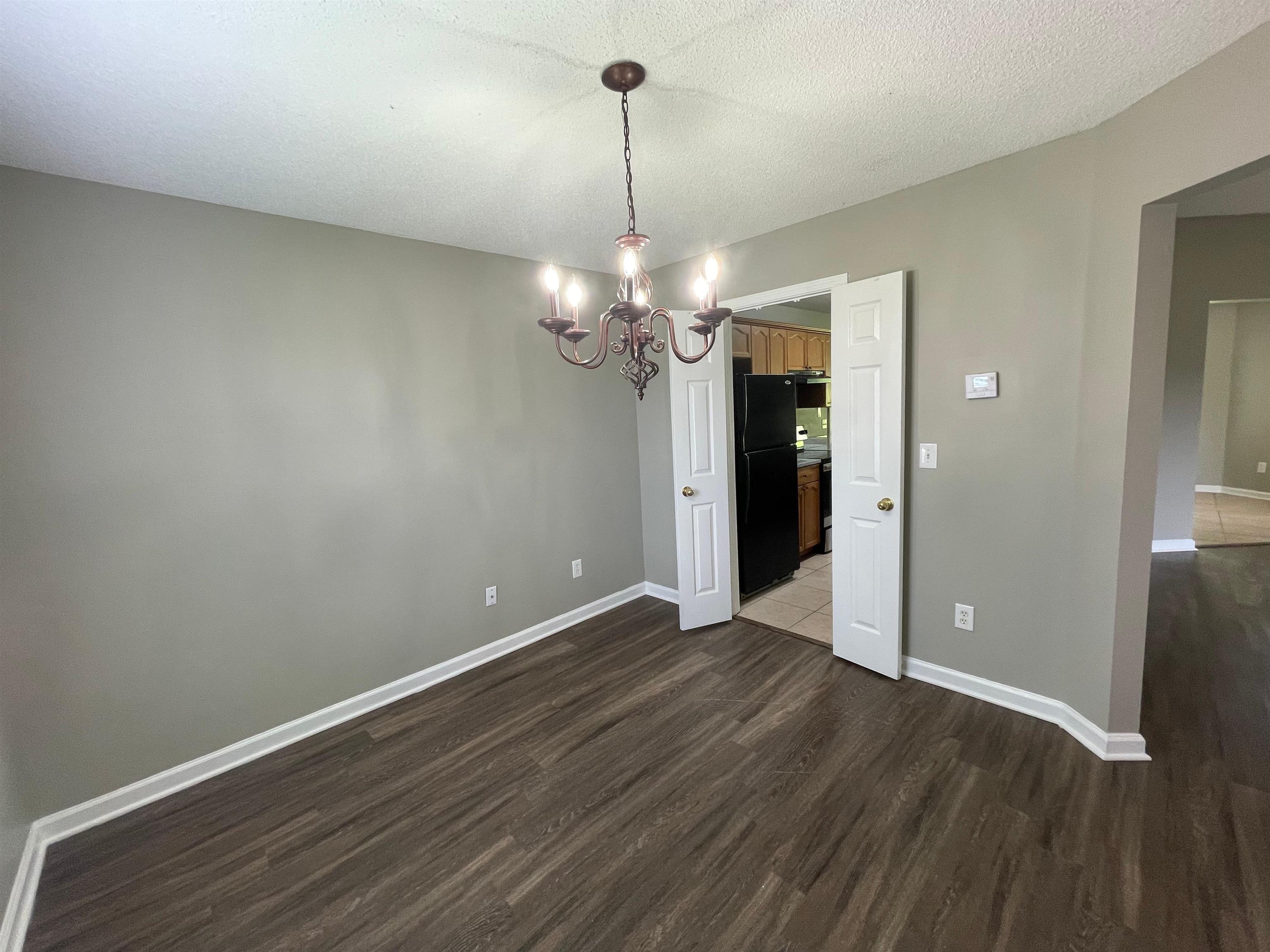 4580 Sun Ridge Drive Memphis, TN 38128 - Photo 3 of 16 Unfurnished dining area featuring dark wood-style flooring and a chandelier