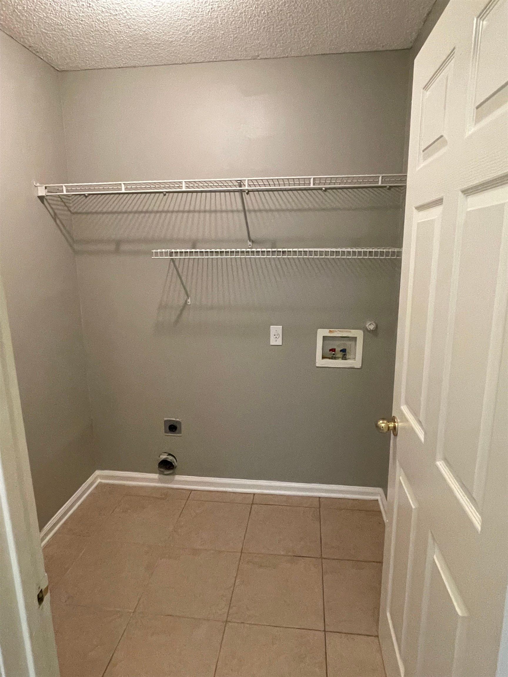 4580 Sun Ridge Drive Memphis, TN 38128 - Photo 8 of 16 Laundry room featuring hookup for an electric dryer, hookup for a washing machine, tile patterned flooring, gas dryer hookup, and a textured ceiling