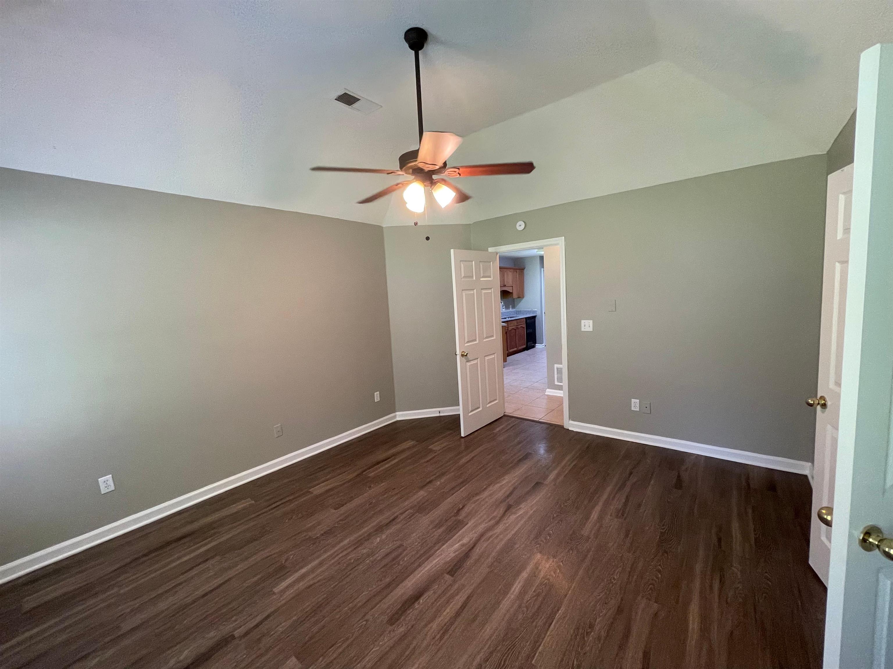 4580 Sun Ridge Drive Memphis, TN 38128 - Photo 9 of 16 Empty room featuring a ceiling fan, dark wood finished floors, and lofted ceiling
