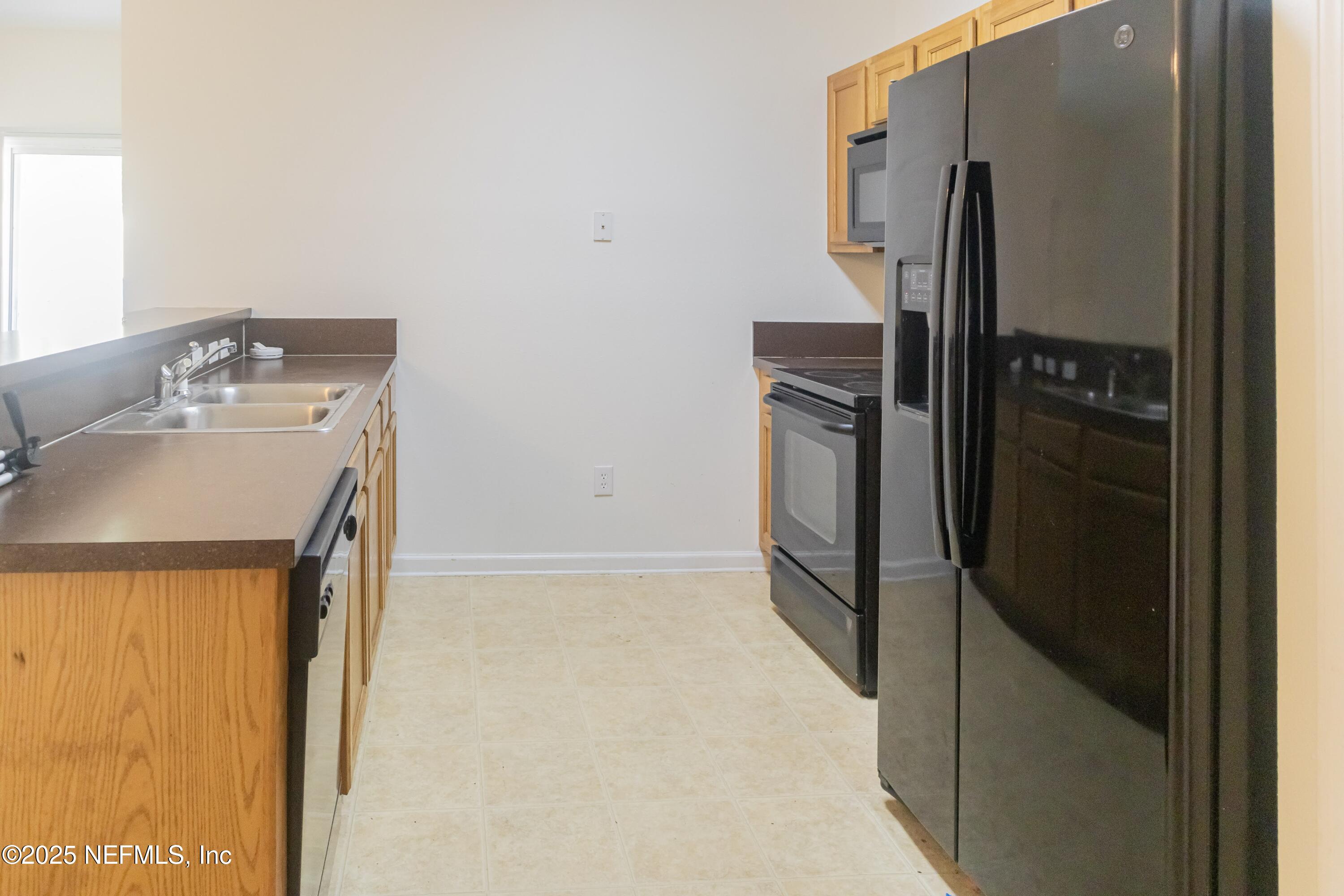 3680 Kirkpatrick Circle, Unit 5 Jacksonville, FL 32210 - Photo 2 of 10 a kitchen with a refrigerator and a sink