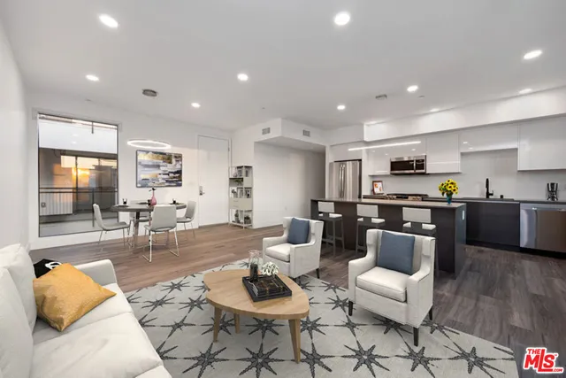 a living room with furniture and kitchen view