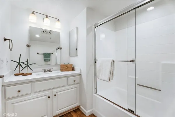 a bathroom with a shower sink and mirror