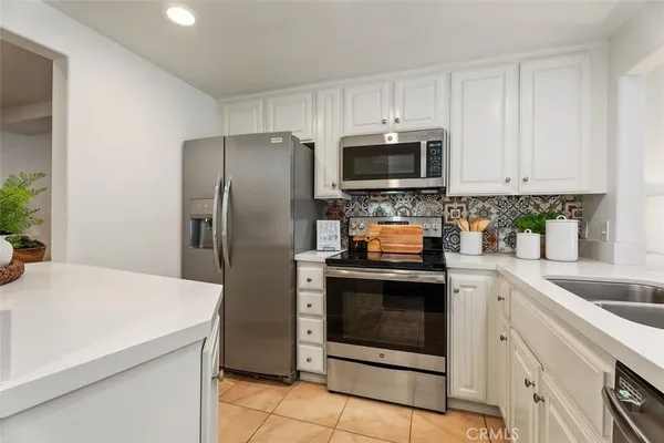 a kitchen with cabinets stainless steel appliances and sink