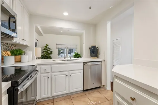 a kitchen with white cabinets and sink