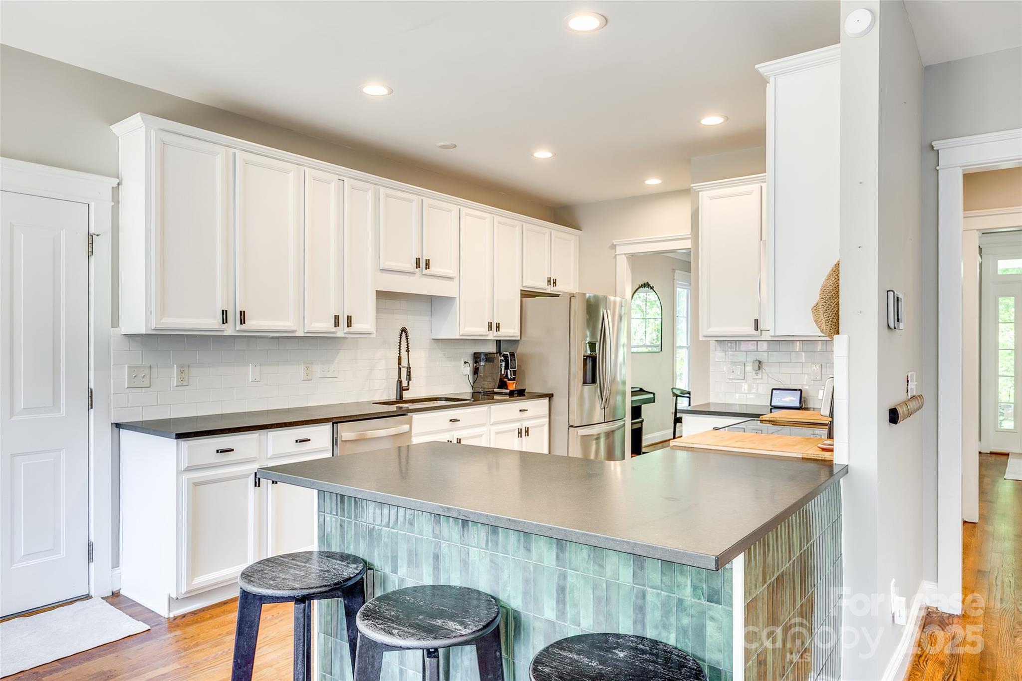 1128 Windsong Bay Lane Fort Mill, SC 29708 - Photo 8 of 35 a kitchen with stainless steel appliances granite countertop a sink a stove a refrigerator and white cabinets with wooden floor
