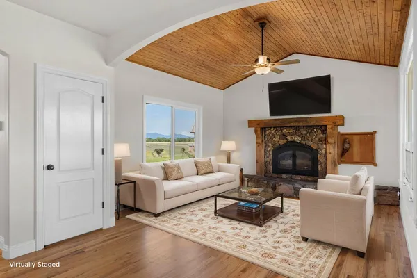 a living room with furniture a flat screen tv and a fireplace