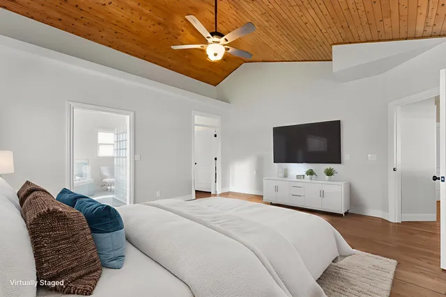 a bedroom with bed tv and a window