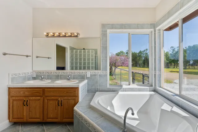 a bathroom with a granite countertop sink and a bathtub