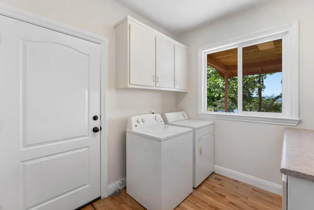 a utility room with wooden floor washer and dryer