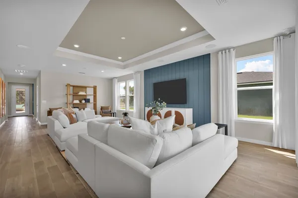 a living room with furniture kitchen view and a large window