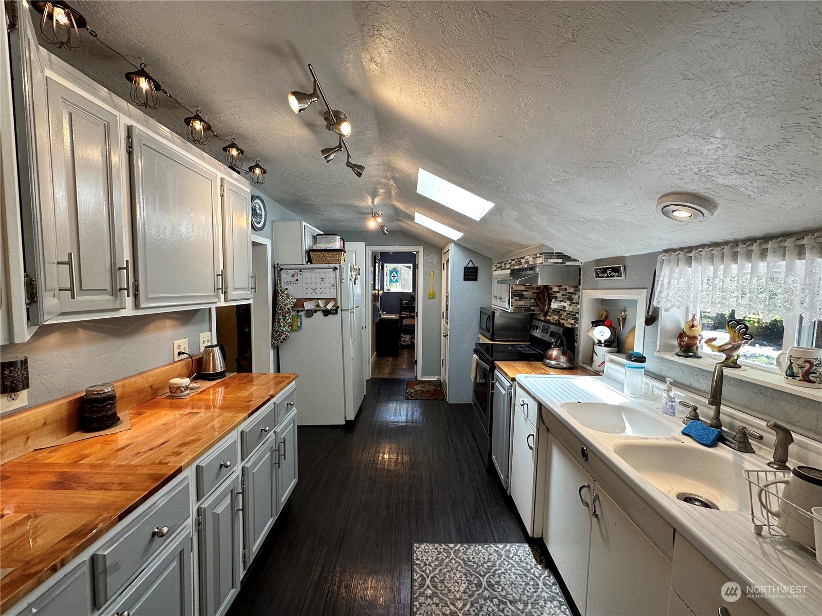 732 Gasman Road Port Angeles, WA 98362 - Photo 10 of 35 a large kitchen with stainless steel appliances lots of counter space and wooden floor